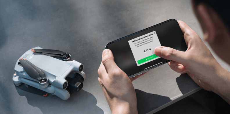Imagem de um homem segurando o celular horizontalmente com as duas mãos prestes a ativar o recurso de QuickTransfer do DJI Mini 3 Pro